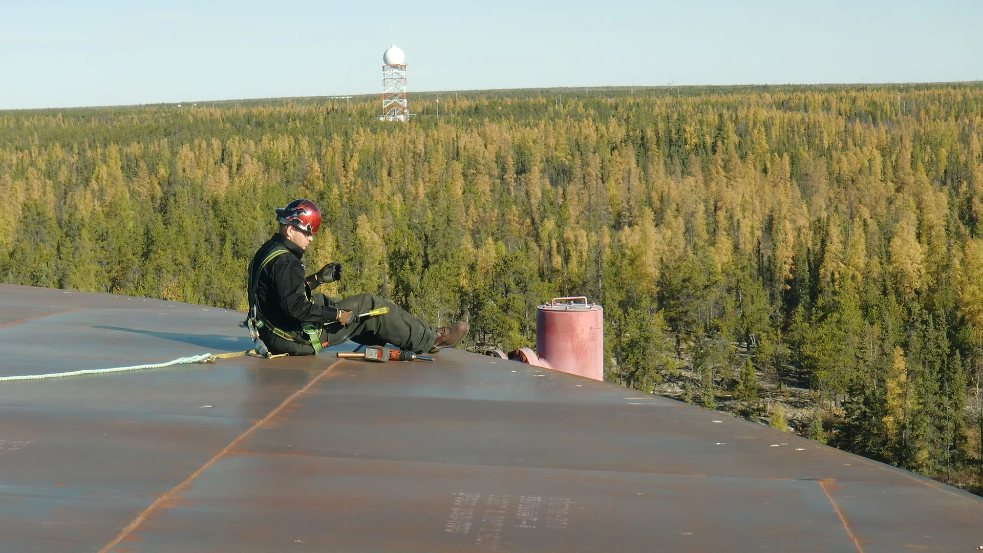 Man sitting on tank inspecting foam chamber